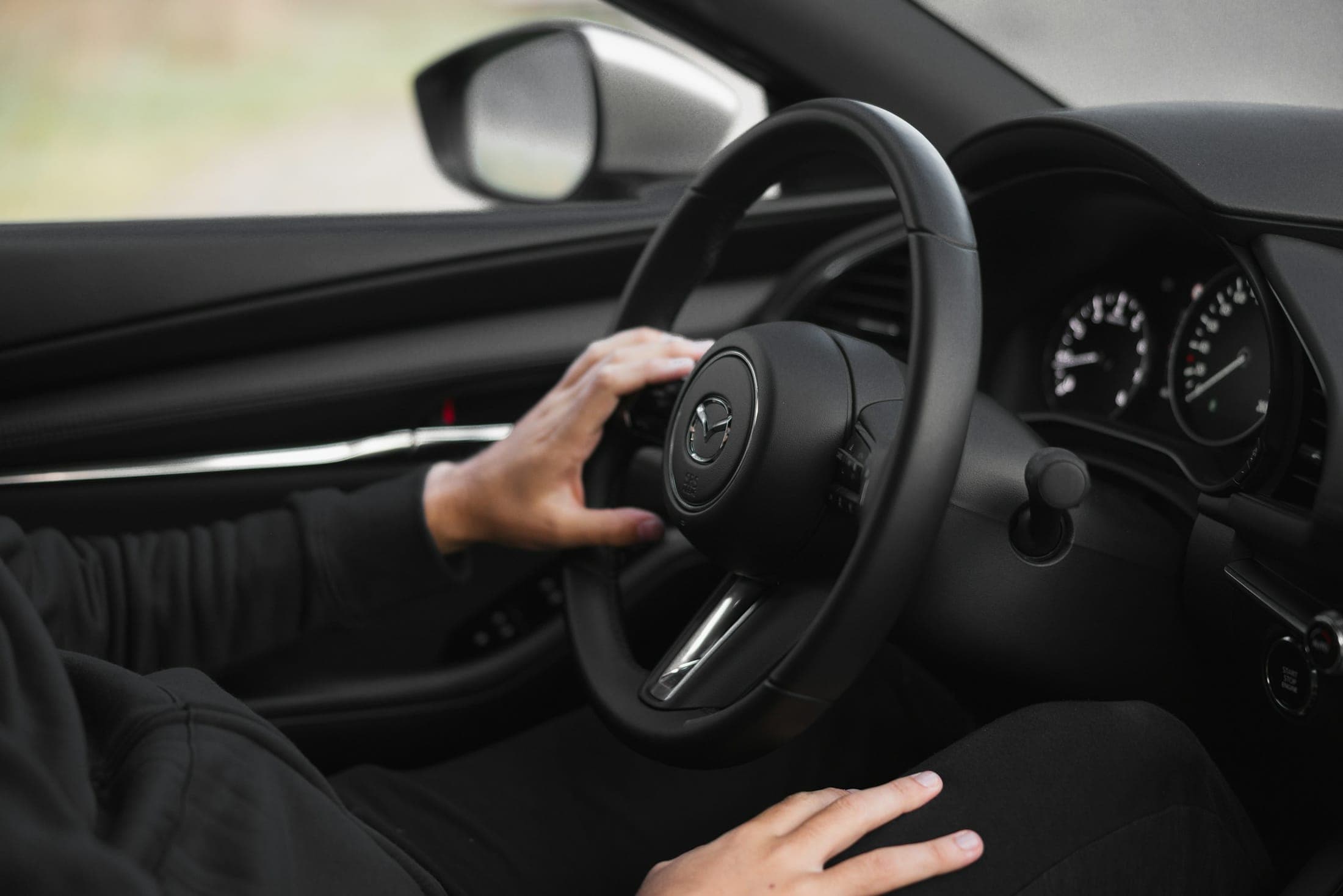 Leçon de conduite : la main d'un élève sur le volant, tableau de bord au premier plan